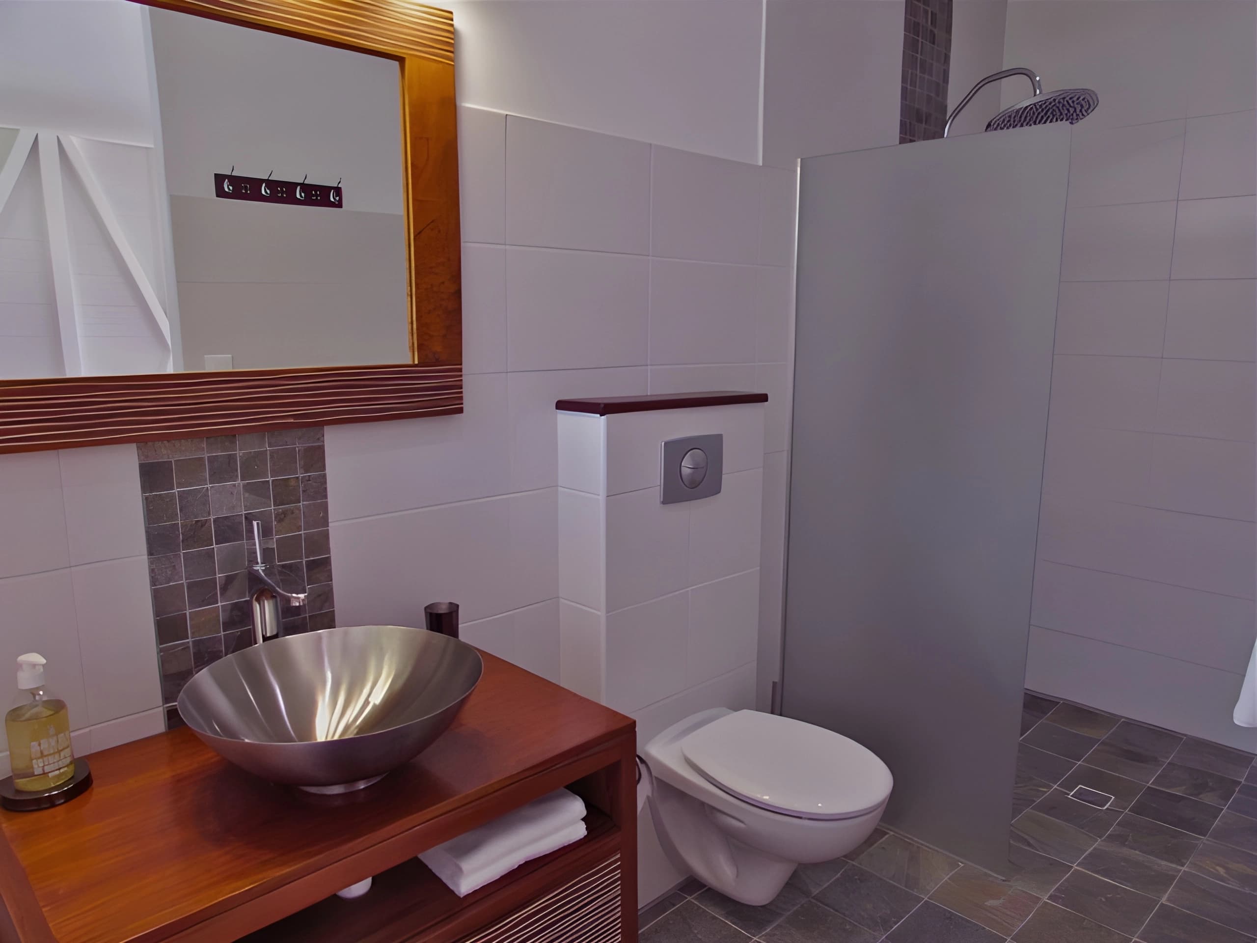 Salle de bain avec vasque sur meuble bois et douche à l'italienne