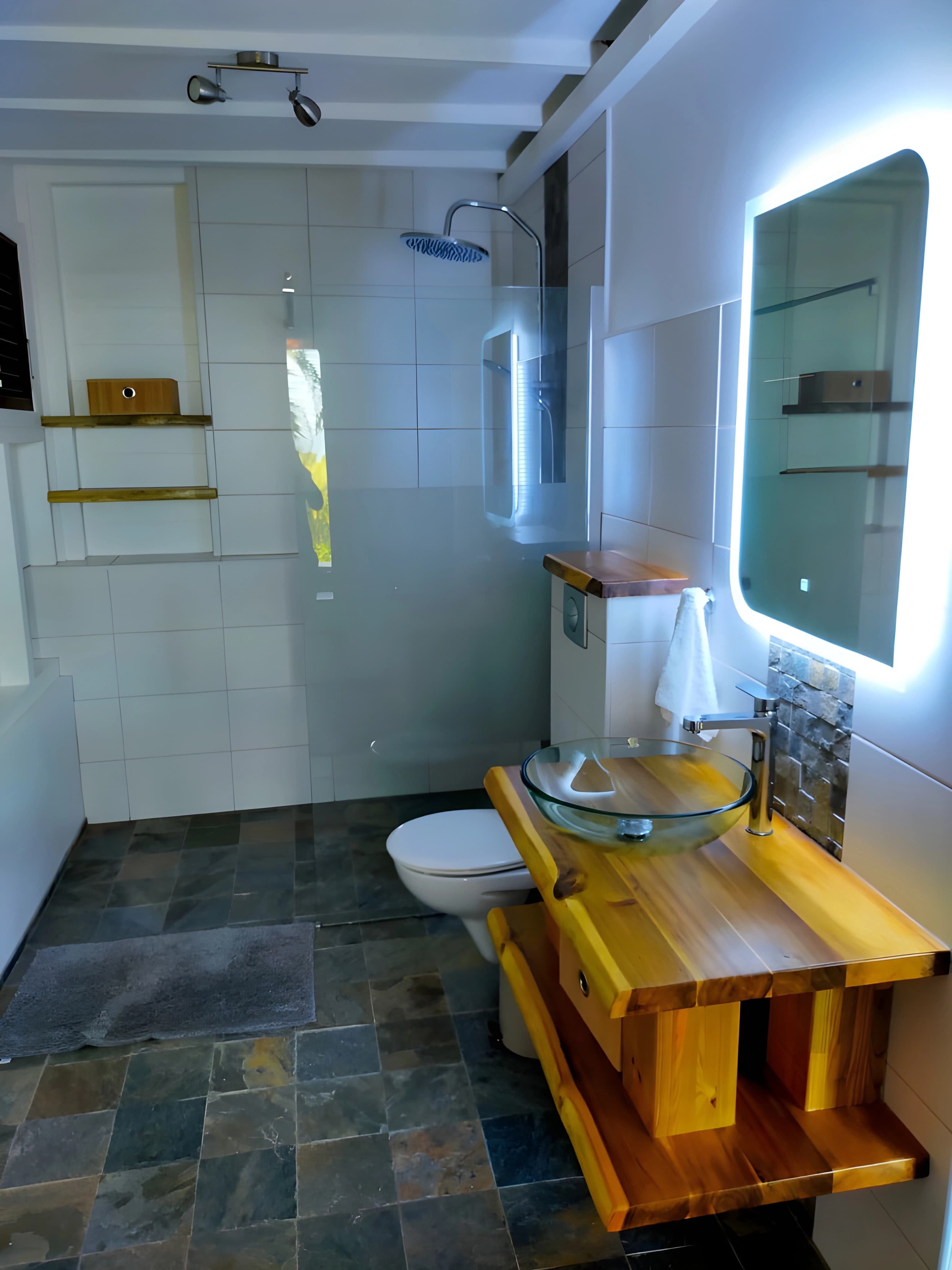 Salle d'eau avec vasque, miroir lumineux et meuble en bois massif