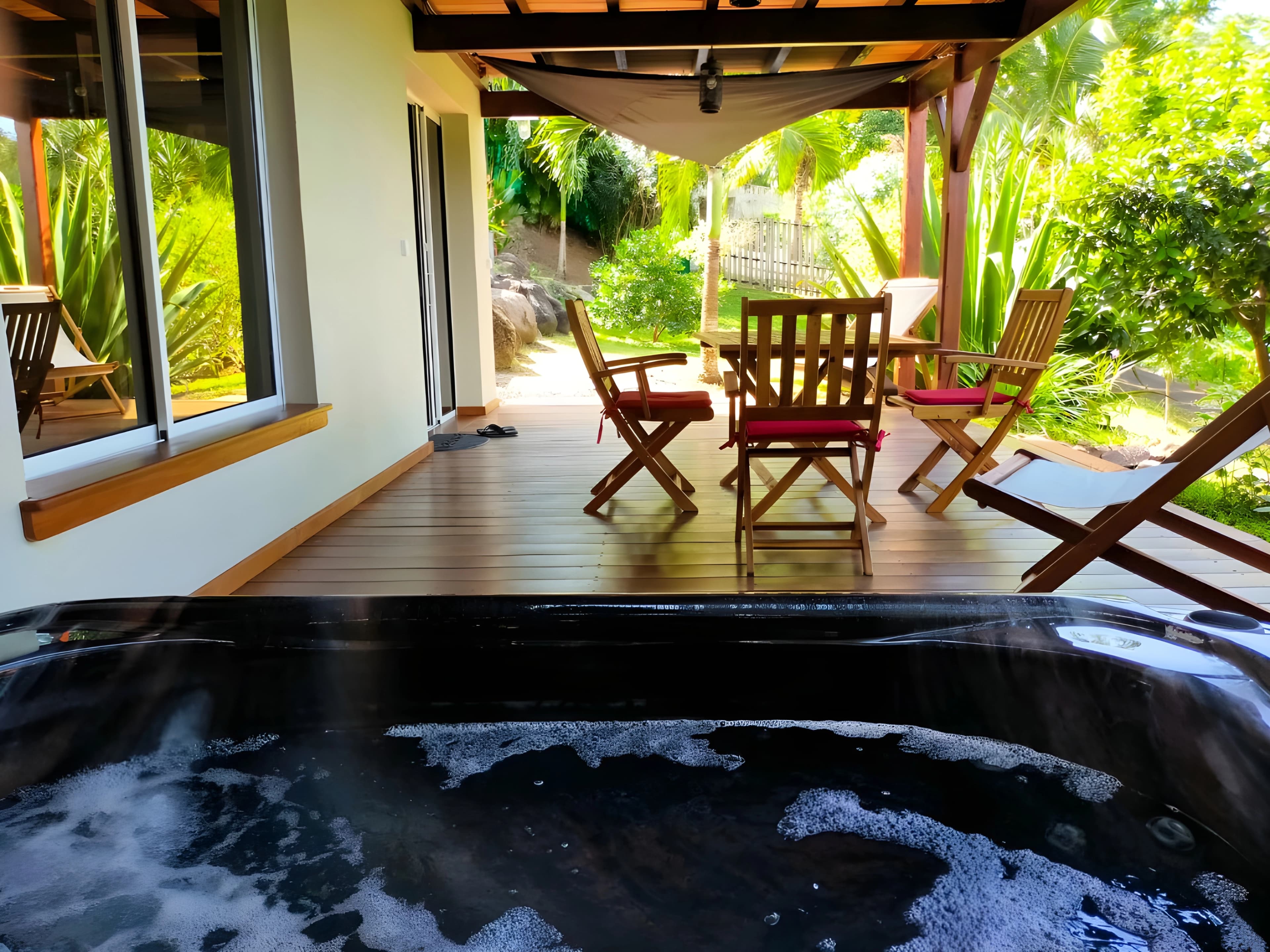 Jacuzzi privatif sur la terrasse en bois, ouvert sur le jardin