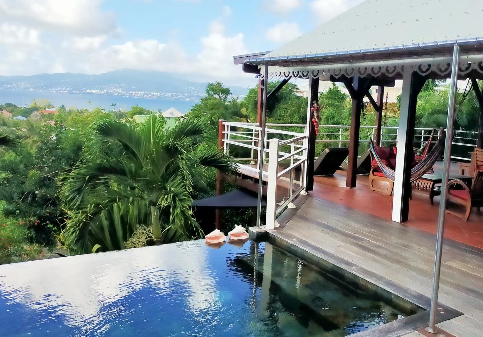 Piscine à débordement et terrasse couverte, baie de Fort-de-France au fond