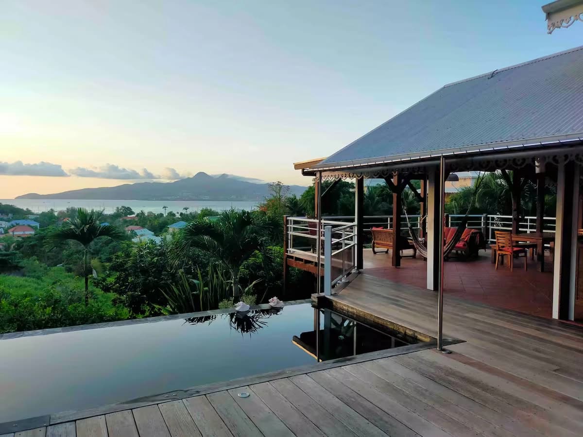 Piscine à débordement au lever du jour, terrasse et baie de Fort-de-France
